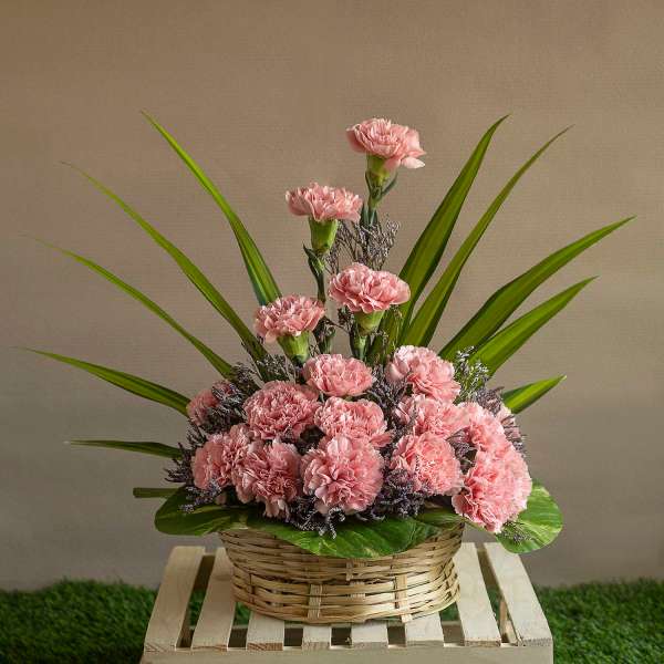 Arrangement Of Pink Carnations And Leaves In A Basket