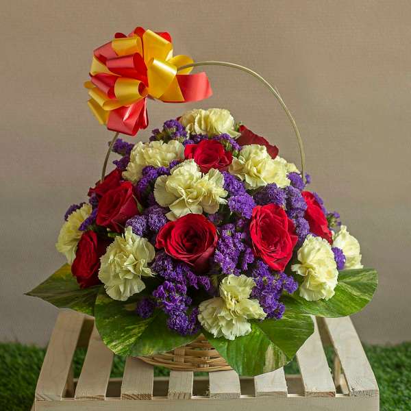 Basket of red roses, carnations and Purple Statices