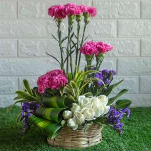 Pink carnations ,white roses and purple statice in a basket