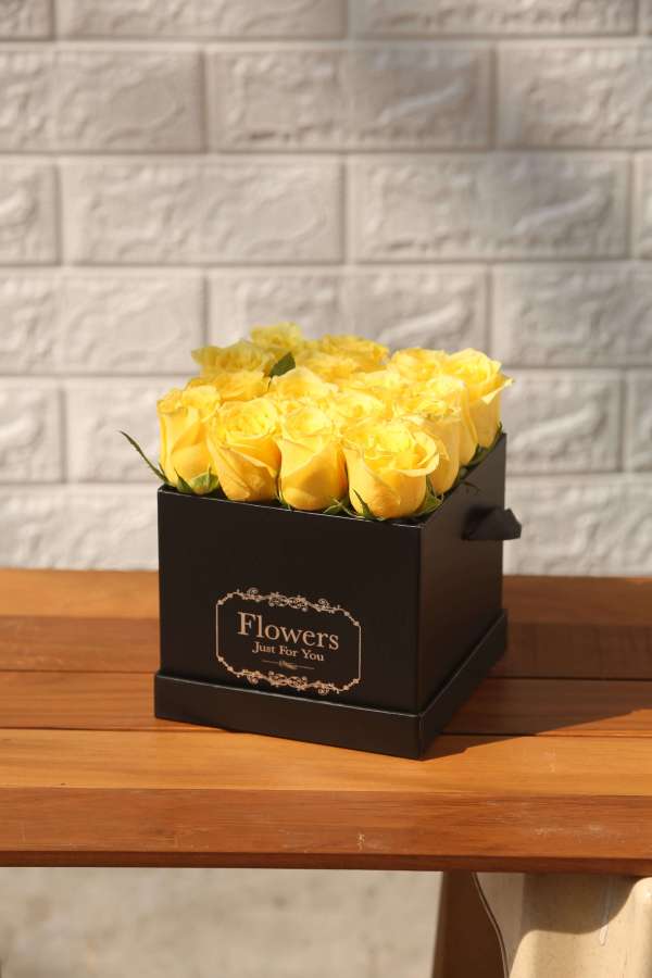 Yellow roses in a black box