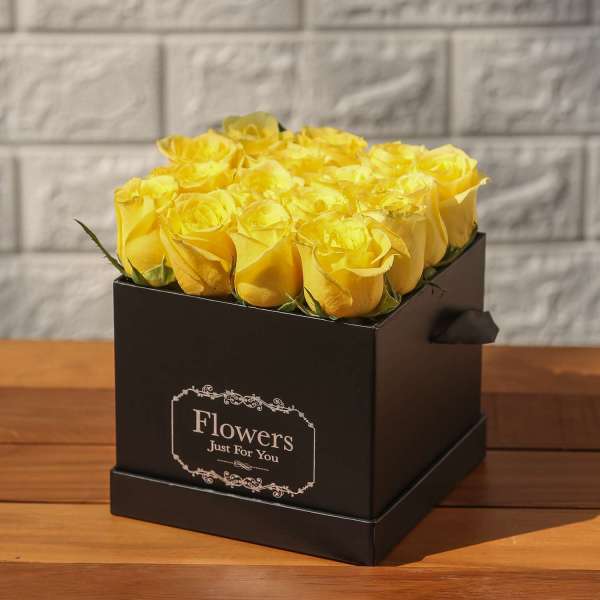 Yellow roses in a black box